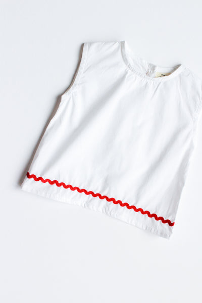 White sleeveless top with red ric rac trim