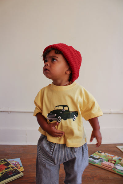 Toddler girl wearing red beanie and yellow t-shirt with green chevy truck graphic 