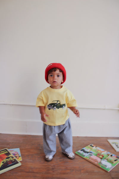 Toddler girl wearing red beanie and yellow t-shirt with green chevy truck graphic 