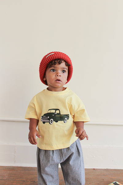 Toddler girl wearing red beanie and yellow t-shirt with green chevy truck graphic 