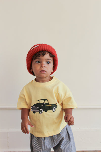 Toddler girl wearing red beanie and yellow t-shirt with green chevy truck graphic 