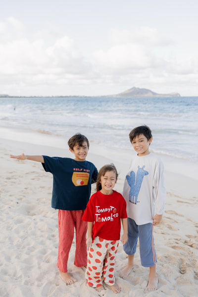3 children wearing a navy blue, red, and beige t-shirts 