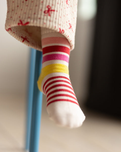 Colorful striped socks worn by a child with a blurred background