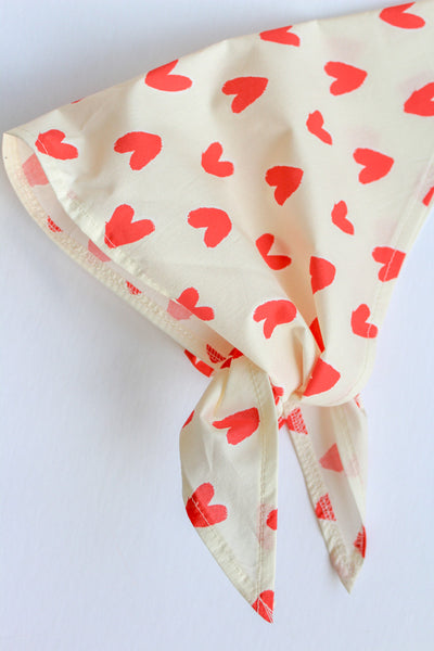 Off white scarf with red heart patterns on a white background