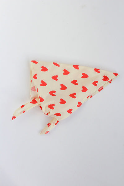 Triangular bandana with red heart pattern on a white background