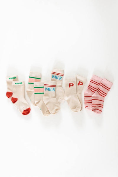 A collection of children's socks with colorful accents and text patterns, displayed on a white background.