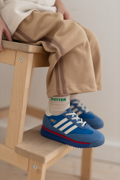 a child wearing socks with the words butter written in green 