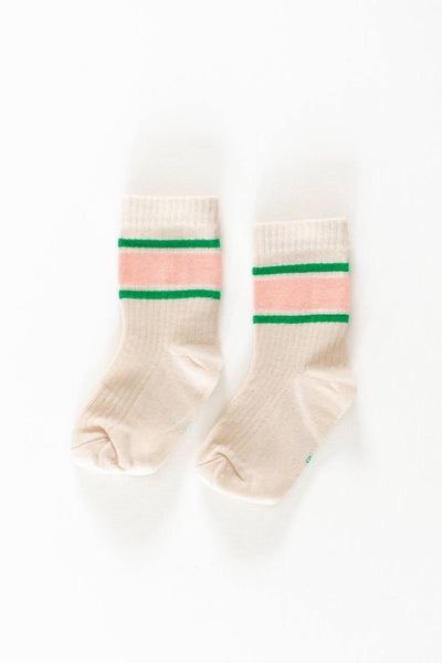 A pair of socks with horizontal watermelon stripe patterns in pink and green colors on a beige background.
