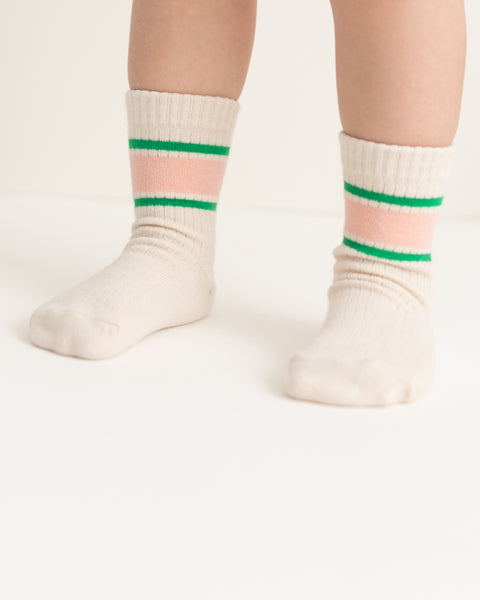 A pair of socks with horizontal watermelon stripe patterns in pink and green colors on a beige background.