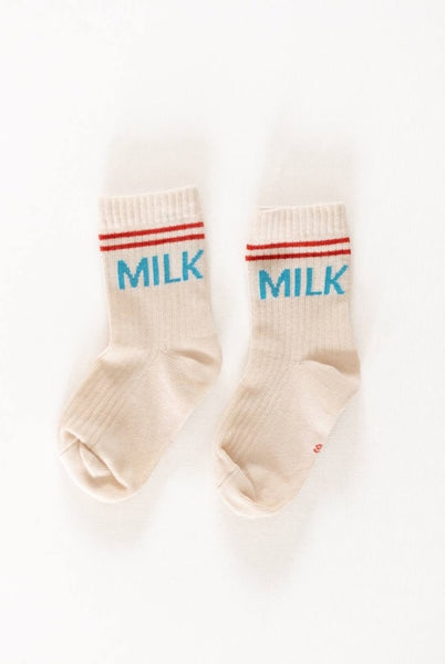 A pair of white crew socks with the word 'Milk' printed in blue, placed side by side against a white background.