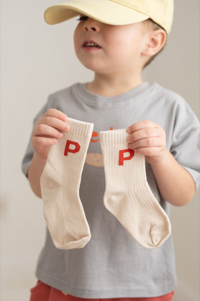 A pair of white crew socks with the letter 'P' printed in red on each foot