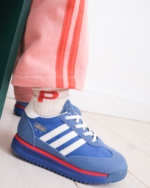 A pair of white crew socks with the letter 'P' printed in red on each foot