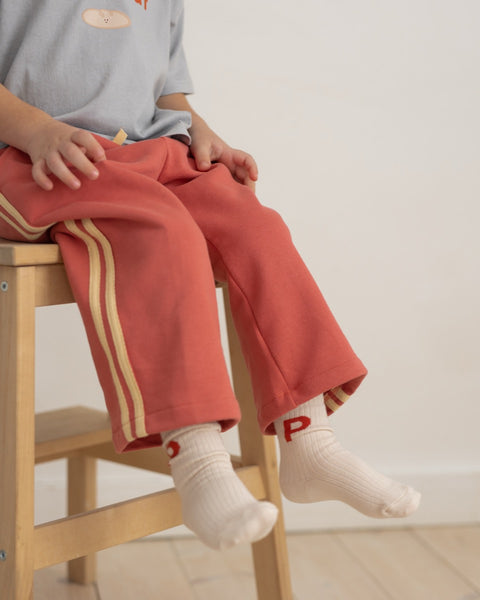child wearing a pair of socks with the letter P 
