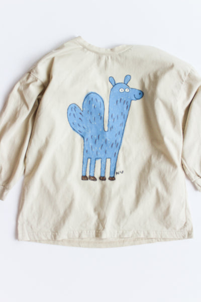Beige long-sleeve shirt with a blue cartoon llama design on a white background