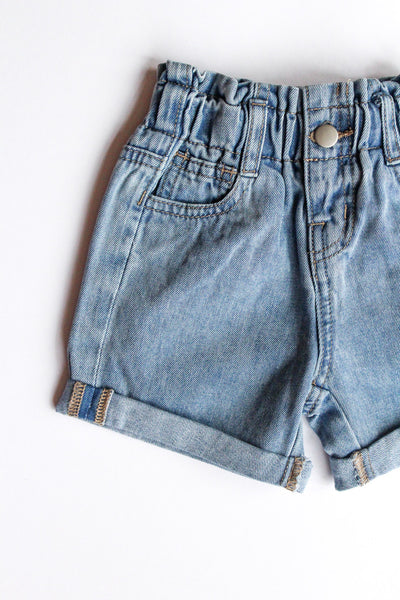 Pair of light blue denim shorts on a white background
