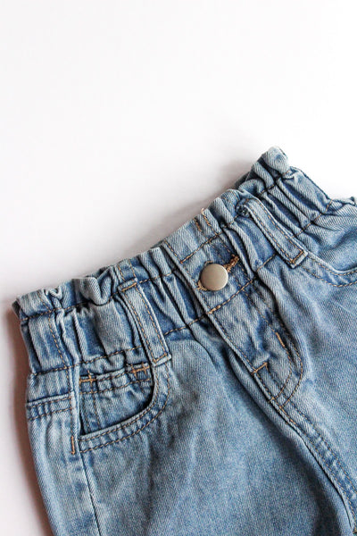 Close-up of denim shorts with a white background