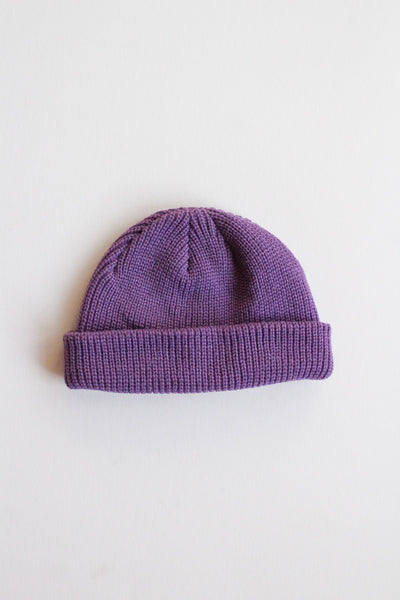 Purple knit beanie on a light gray background