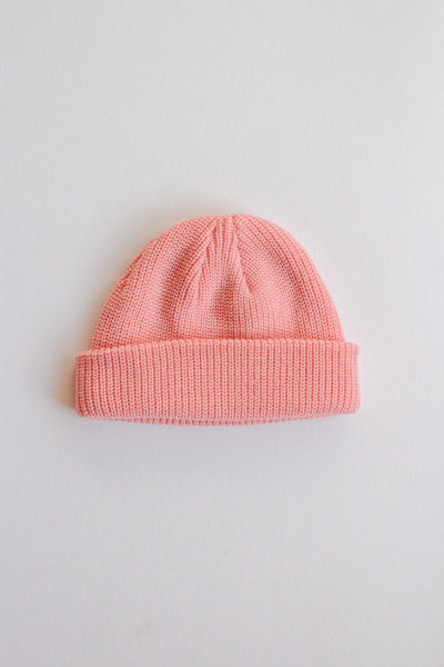 Pink knit beanie on a light gray background