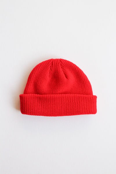 Red knit beanie on a light gray background