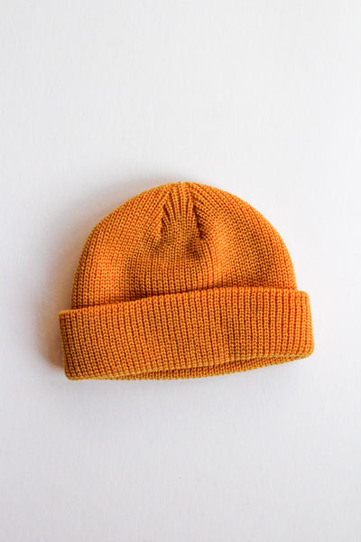 Orange knit beanie on a light gray background