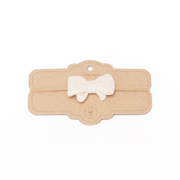 a white bow on a headband for babies 