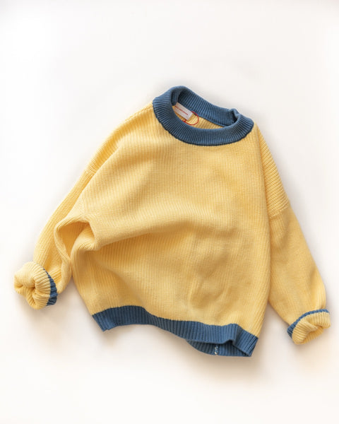 Yellow sweater with blue trim on a white background