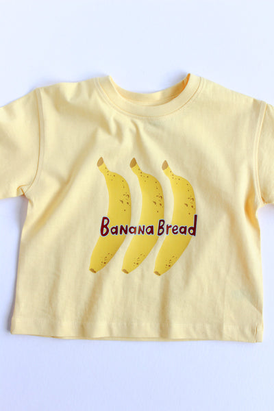 Yellow t-shirt with banana design and 'Banana Bread' text on a white background