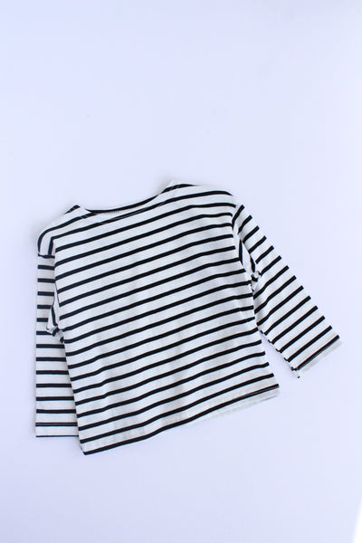 A long-sleeve striped top with horizontal black and white stripes, laid flat on a light gray background.