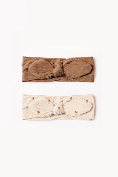Two headbands, one brown and one white with gold dots, displayed on a white background.