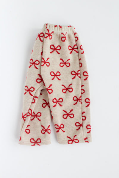 Beige pants with red bow pattern on a white background