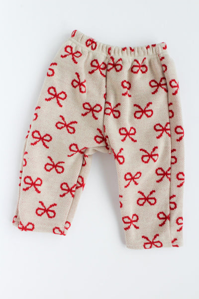 Beige pants with red bow pattern on a white background