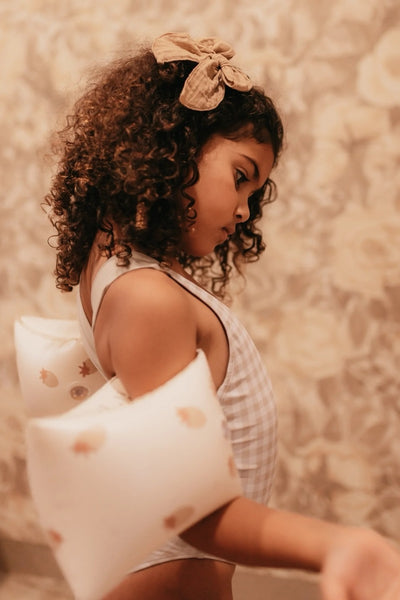 A child wearing inflatable armbands in a swimming pool