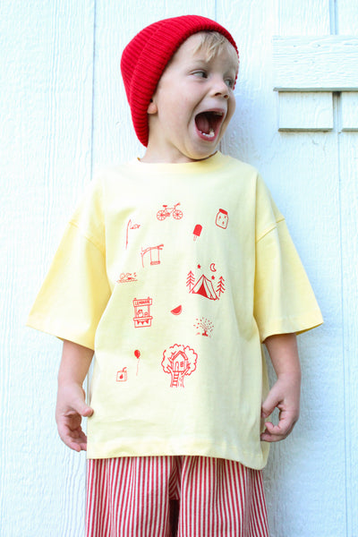 Kids yellow cotton t-shirt with hand-drawn orange childhood doodles on front and Long live childhood graphic on back