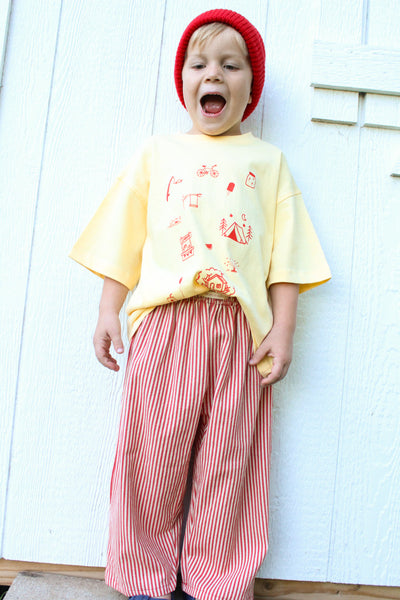 Kids yellow cotton t-shirt with hand-drawn orange childhood doodles on front and Long live childhood graphic on back