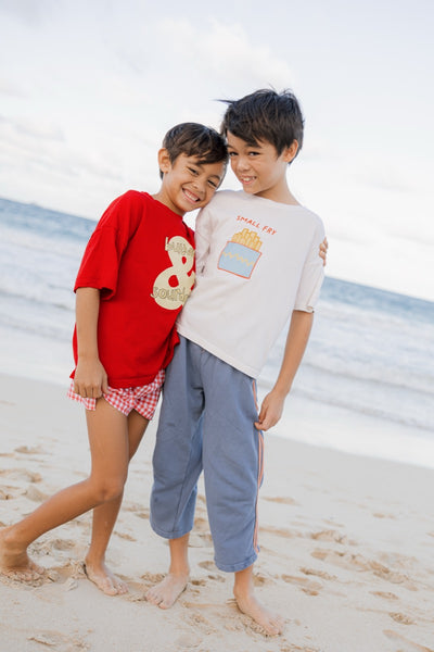 Two children wearing a red sourdough t-shirt and white t-shirt with small fry graphic 