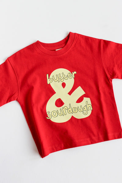 Red t-shirt with gold 'butter & sourdough' graphic on a white background