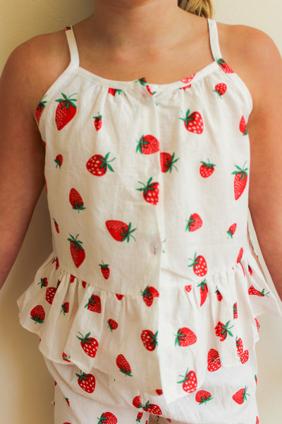 White tank top with red strawberry pattern worn by a toddler girl