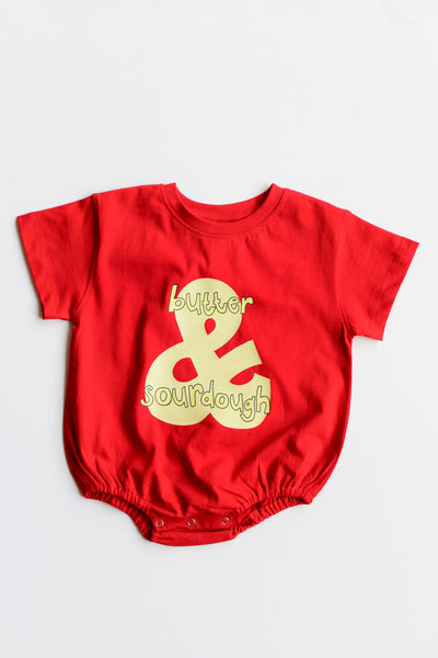 Red baby romper with 'butter & sourdough' graphic on a white background
