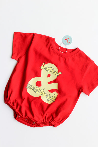 Red baby romper with butter & sourdough graphic on a white background