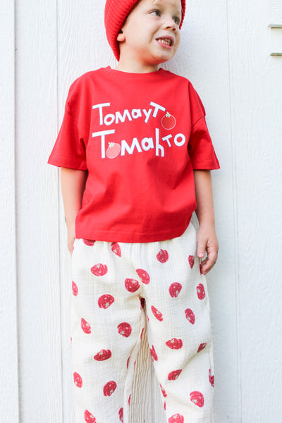 Kid wearing cream cotton muslin pants with red tomato print and elastic waist and our red Tomayto Tomahto t-shirt 