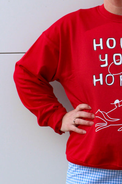 Person wearing a red sweatshirt with white text and graphics on a light background